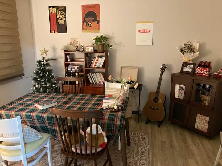 温かみのあるブラウンウッド調のヴィンテージスタイルの書斎兼ダイニングルーム、クリスマスツリーとギターが配置された雰囲気のあるインテリア