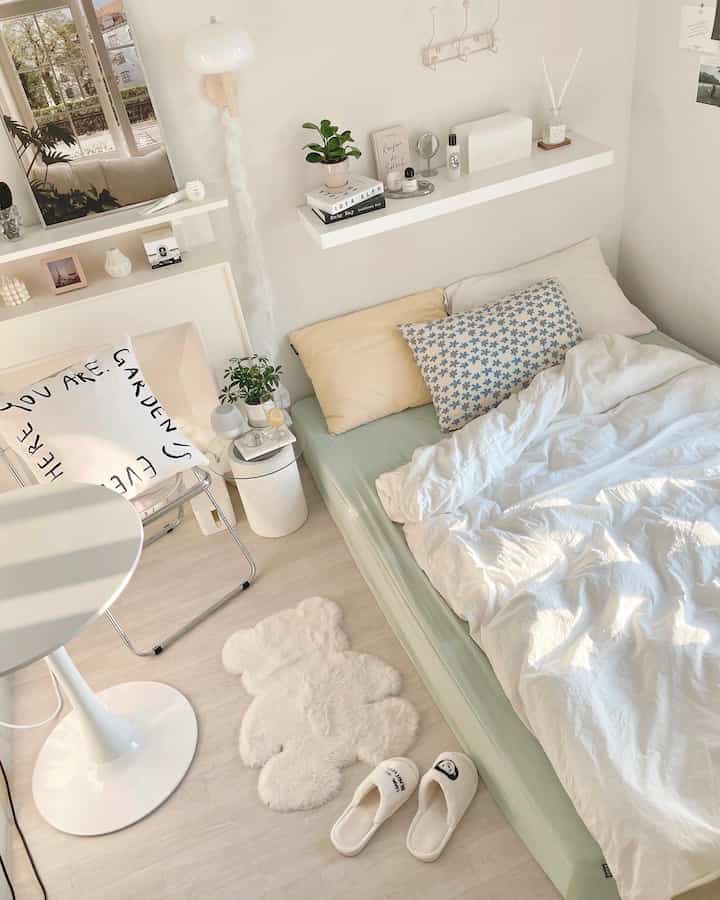 明るく暖かい白とベージュのトーンの寝室、居心地の良いベッドとテディベアラグが配置された落ち着いた空間