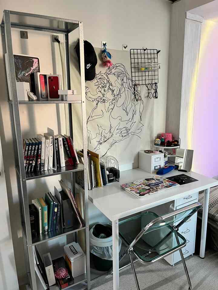 White and silver toned small home office space featuring a desk and metal shelving with a simple, tidy interior
