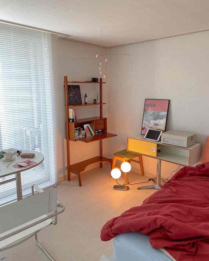 白い壁と木目調家具が調和した寝室、木製の棚やスツール、コンソールテーブルが配置された雰囲気のあるインテリア