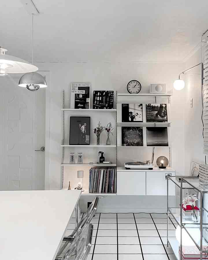 ホワイトとブラックの色調のリビング、壁面棚と多様な照明が配置された印象的なモダンインテリア