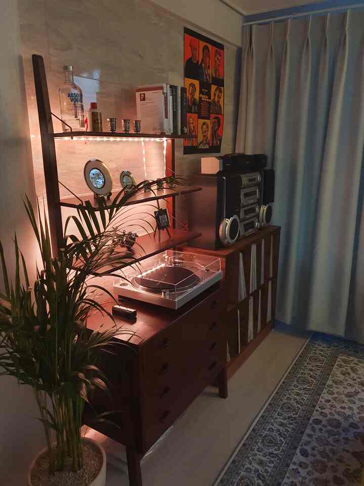 ダークブラウンの木目調家具とスピーカー、ターンテーブル、照明が配置されたヴィンテージ感のある書斎空間