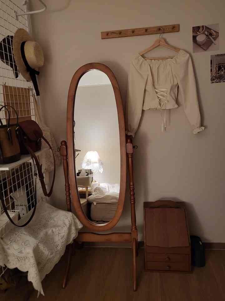 木目調のベースでヴィンテージスタイルの全身鏡と座式ドレッサーが置かれた、落ち着いた雰囲気の寝室