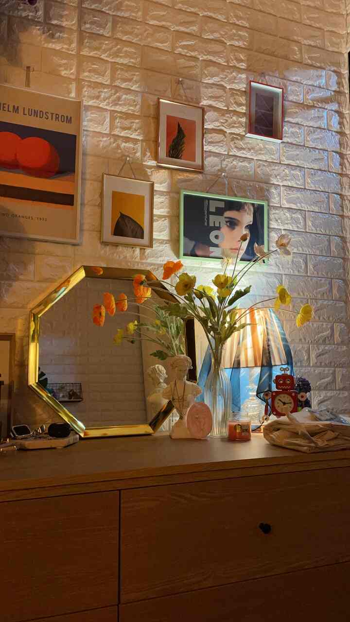 暖かみのあるゴールドとナチュラルウッドトーンの化粧台空間、ヴィンテージポスターと柔らかい照明が印象的な雰囲気を醸し出すインテリア