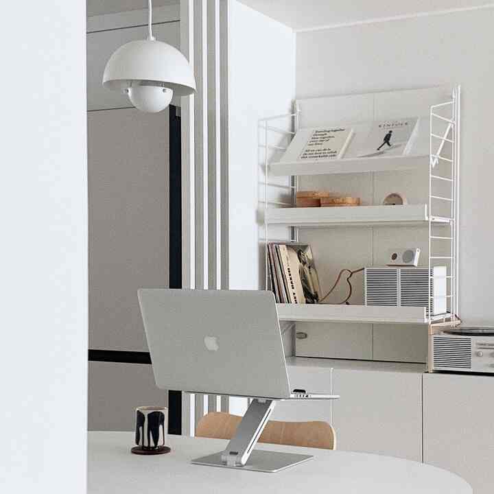 ホワイトトーンのモダンなホームオフィス、ノートパソコンと整った棚が配置された印象的な空間
