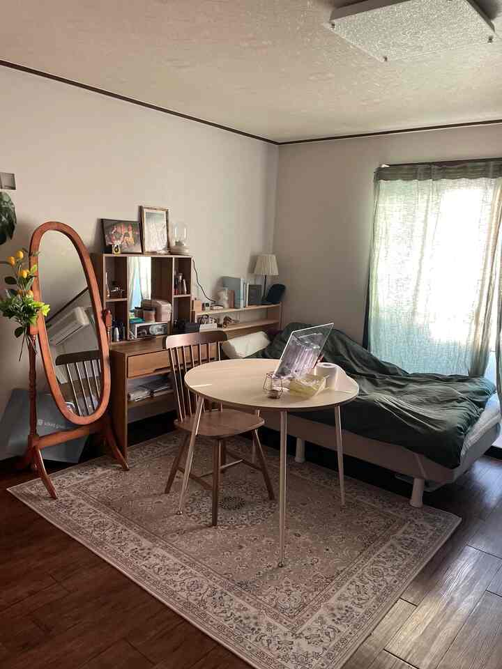Wood tone and natural green 8-pyeong studio apartment featuring a bed, round dining table, and full-length mirror in a vintage style