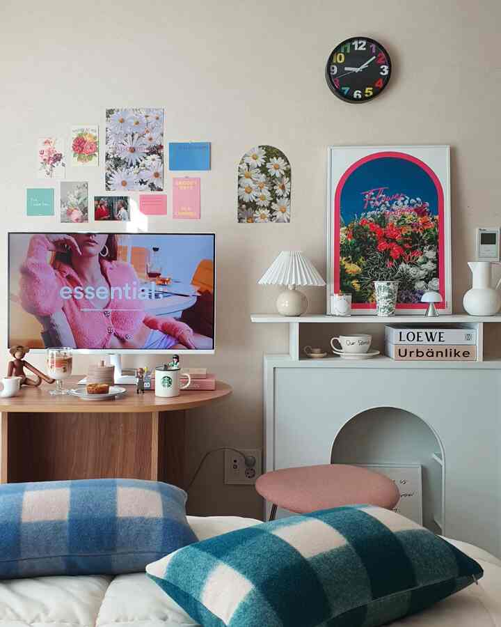 Cozy living room with beige walls, modern table, cushions, and wall posters