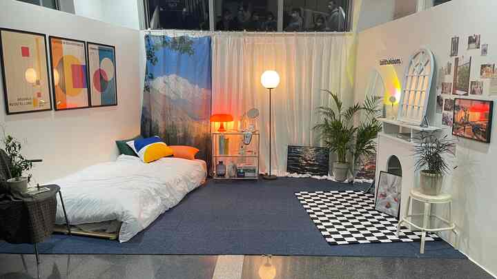 White and blue toned bedroom space featuring mid-century modern bed, rug, and warm lighting arranged as a cozy photo zone