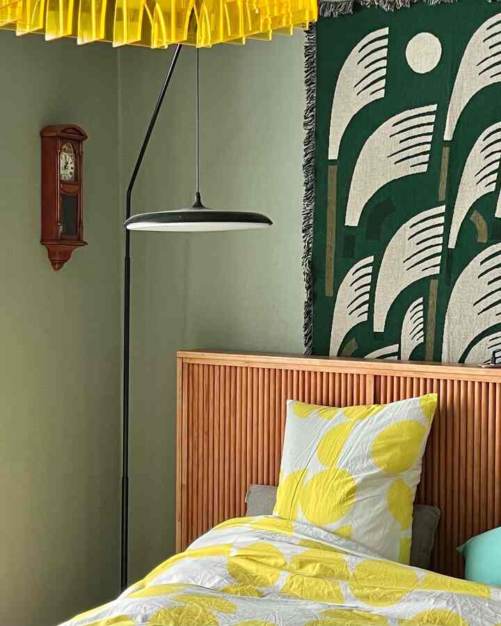 Yellow and wood tone bedroom featuring a wooden bed frame and retro clock with a cozy atmosphere