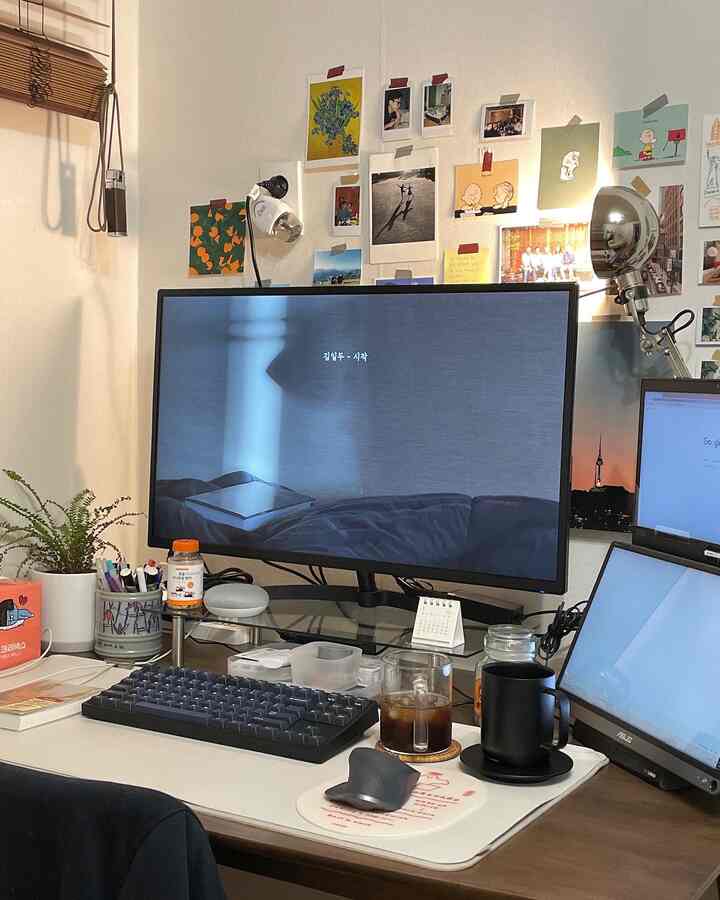 Home office workspace with white walls and brown desk featuring dual monitors and keyboard for remote work