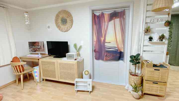 White walls and wood tone furniture blend in a natural home office and living room space featuring computer and TV setups