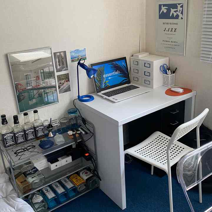 Blue carpet and white desk-centered home office blending remote work setup with a home bar in a tidy interior space