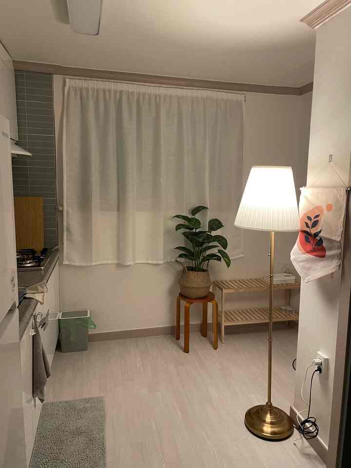 Bright ivory and natural-toned entrance kitchen space featuring wooden stool and floor lamp with cozy atmosphere