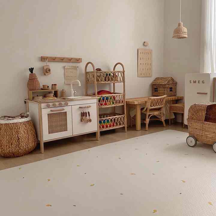 Bright white room featuring natural rattan furniture and a baby play kitchen set in a kids' room interior