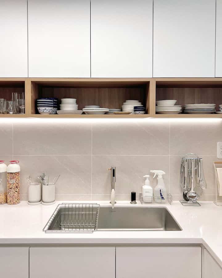 白と木目調が調和したキッチン、オープン棚に器が整理された清潔感のあるシンクエリア