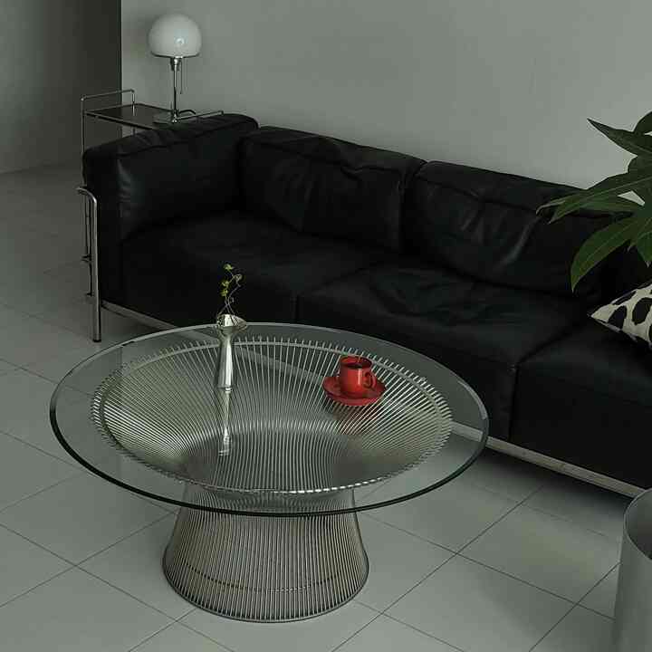 Modern living room with silver tones and black furniture, featuring metal coffee table and leather sofa in a sleek space