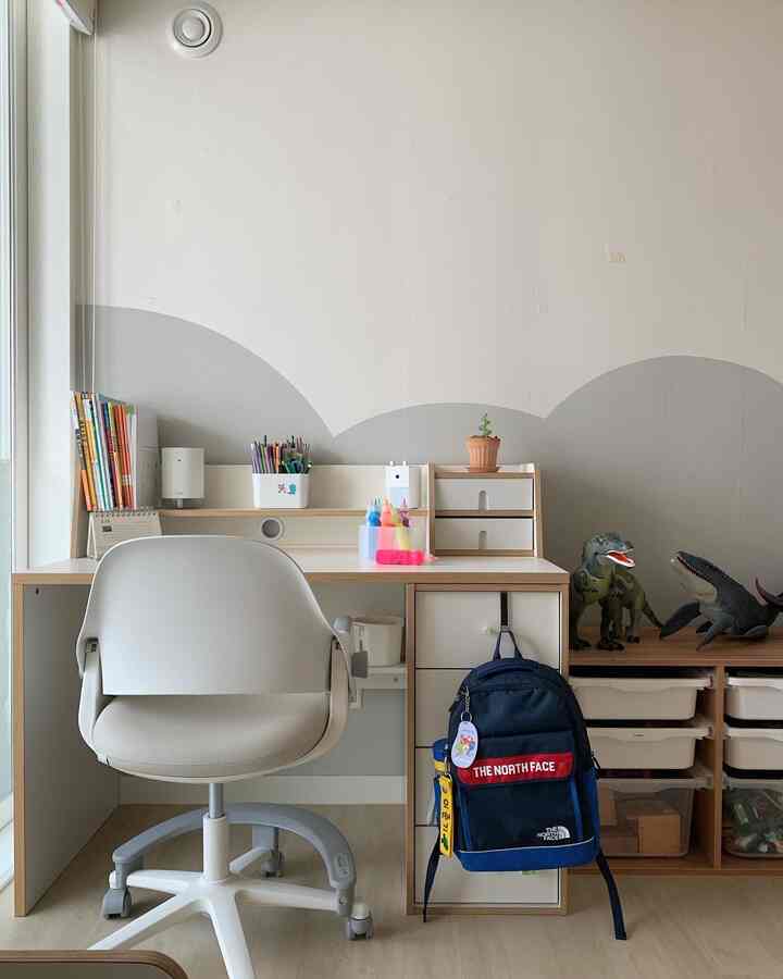 Natural tones and white colors define this kids' study area with desk, chair, and storage neatly arranged in a bright, organized space