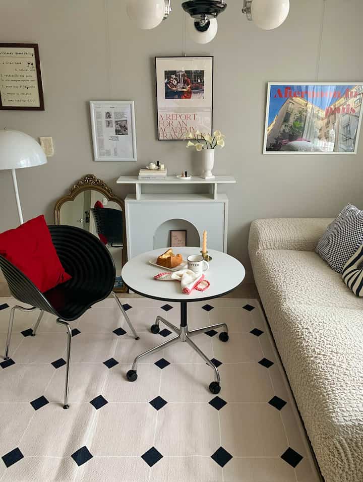 White and black toned living room featuring mid-century modern sofa and chair, a home cafe space with a child