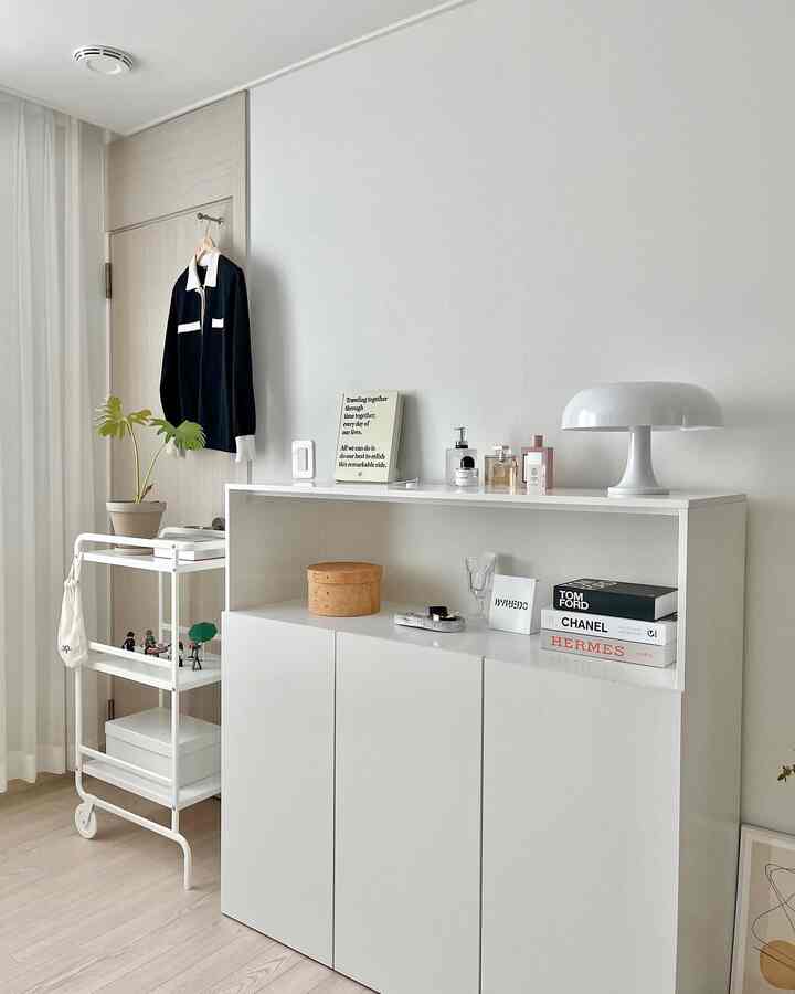 Natural modern living room in white and wood tones featuring a sleek white storage cabinet and minimalist decor