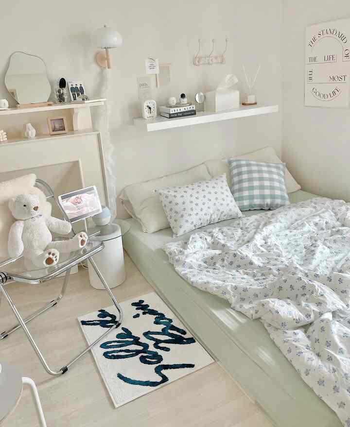 White and beige toned bedroom featuring floral bedding and checkered cushions with cozy atmosphere