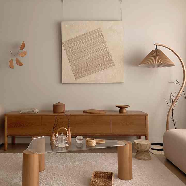 Beige and natural wood-tone living room featuring a glass coffee table and curved floor lamp with a modern natural vibe