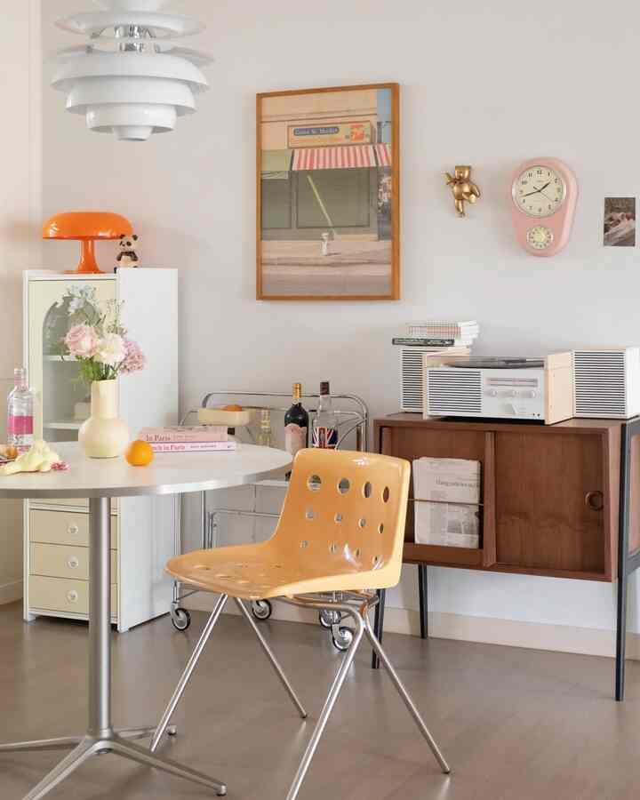 Cozy dining room in warm beige and white tones featuring a round dining table and vintage decor items