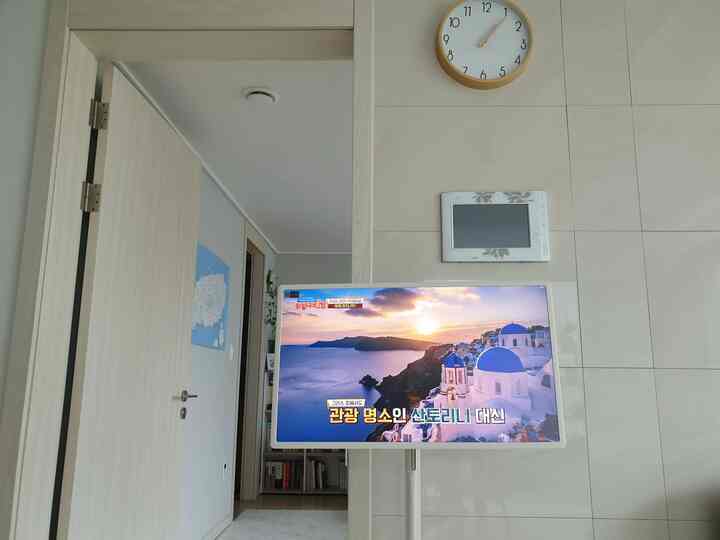 White and natural wood tone living room featuring an LG Smart Screen TV with a clean and comfortable atmosphere