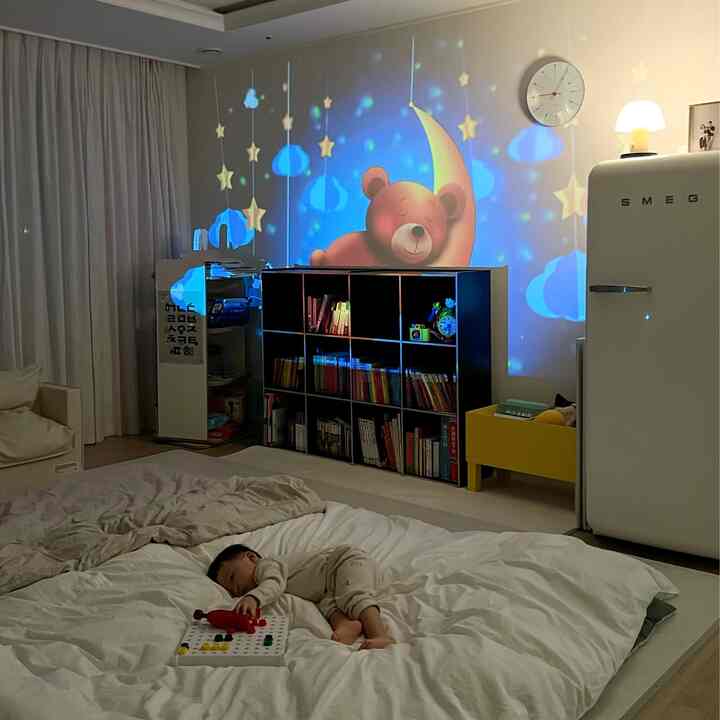 White and black toned kids' bedroom featuring a bed, bookshelf, and storybook wall projection creating a warm, cozy atmosphere