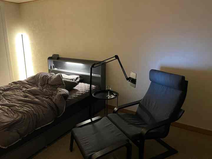 A gray and black toned bedroom featuring a bed and armchair, creating a cozy atmosphere