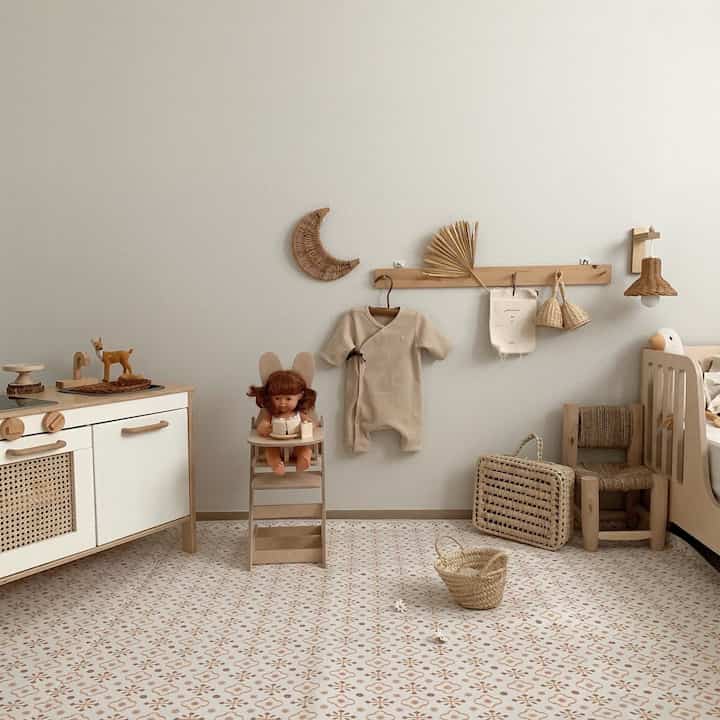Natural colored kids' room featuring baby furniture and a kitchen playset in a cozy space
