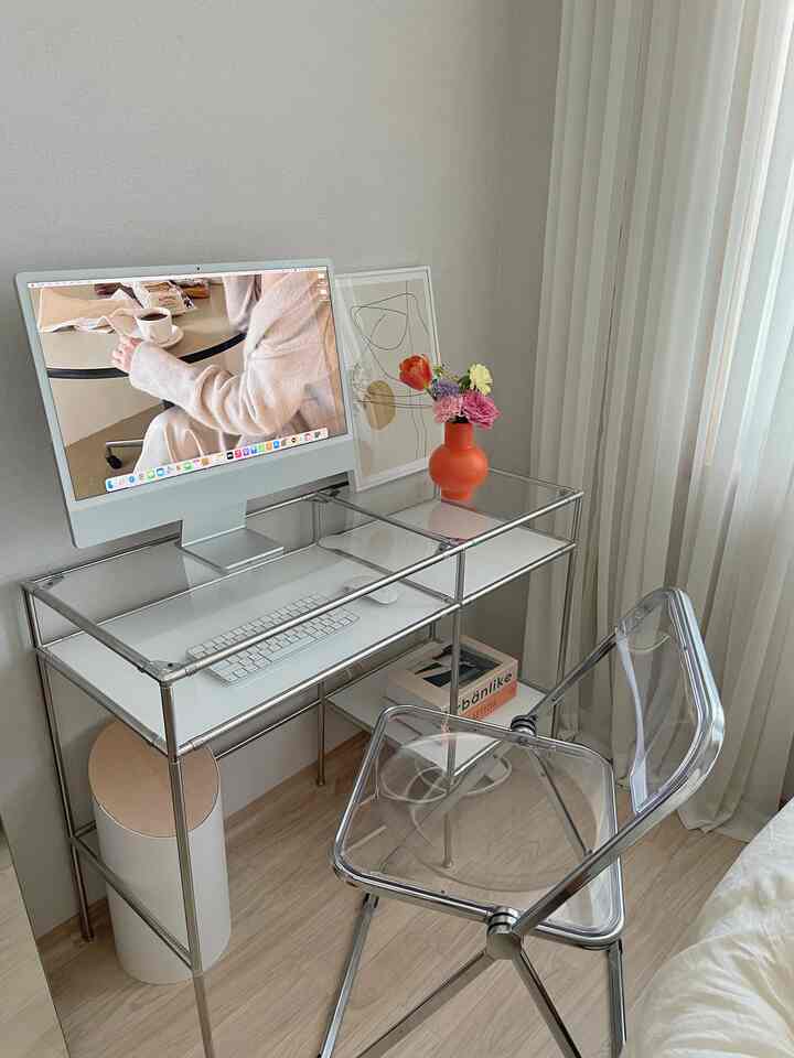 Modern bedroom and home office space blending white and transparent materials, featuring a clear desk and chair with white curtains