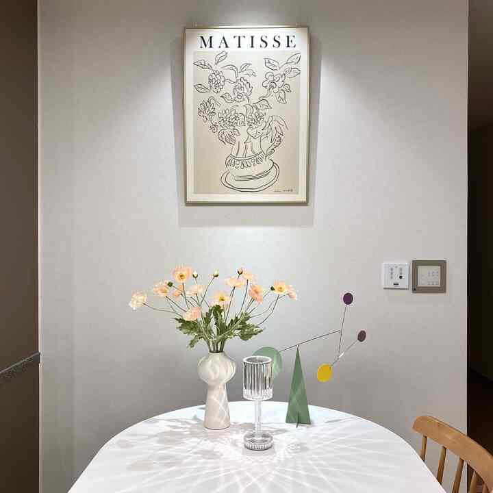 ベージュとホワイトの色調のキッチン、花瓶とモビール、照明が配置されたシンプルで自然な雰囲気のインテリア