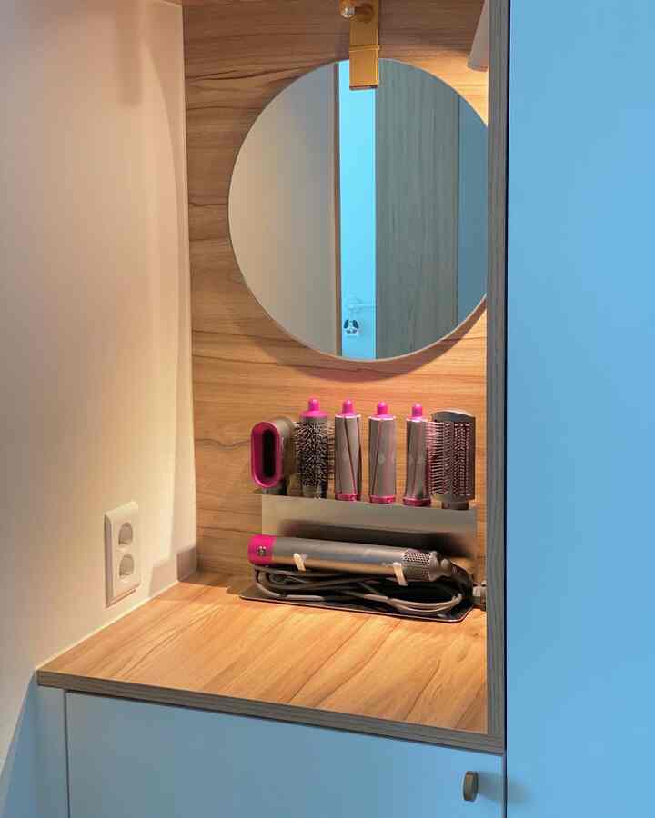 Natural color and white toned studio apartment vanity space featuring a neatly organized Dyson Airwrap styler