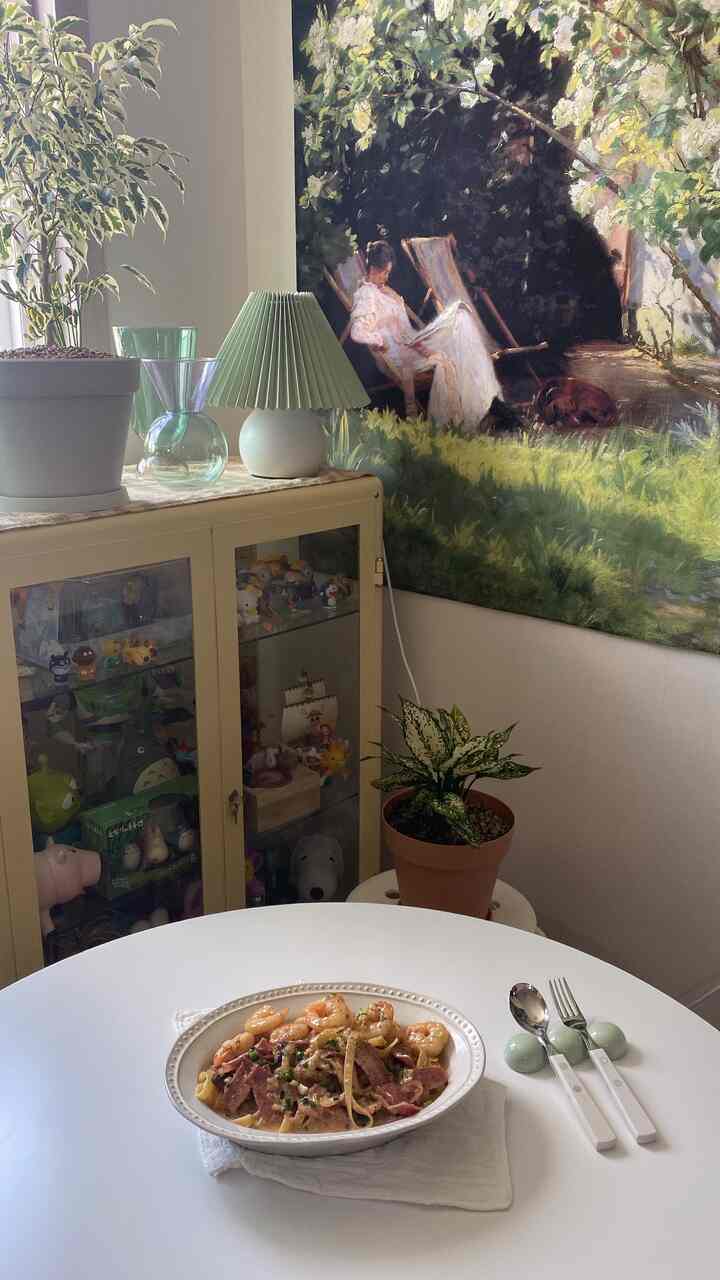 White and beige toned dining room featuring a round table and plants with a natural atmosphere