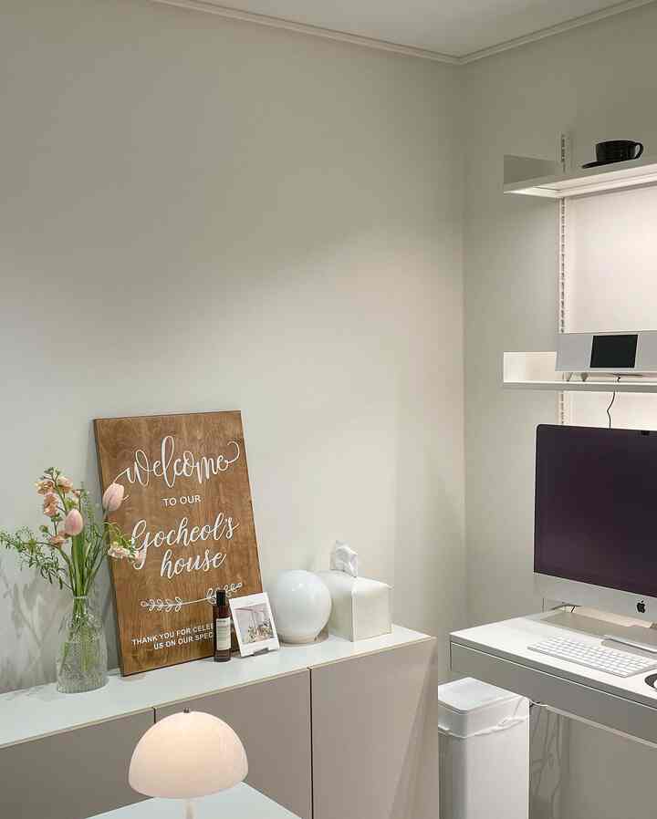 White and natural tone home office space featuring desk and cabinet with clean, simple, and modern interior design