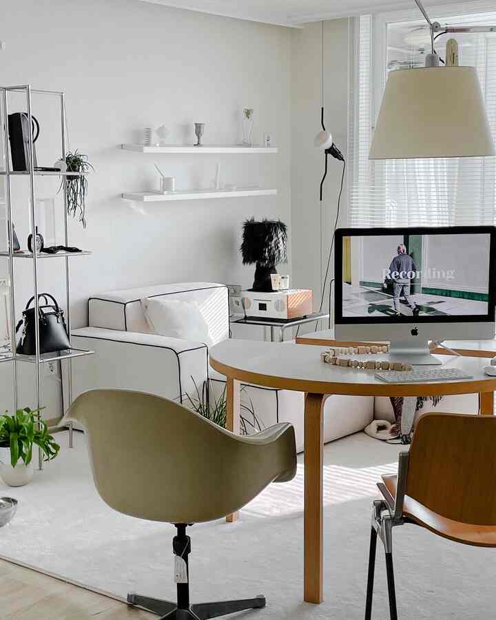 White and wood-tone living room home office space featuring simple, natural modern style with functional furniture