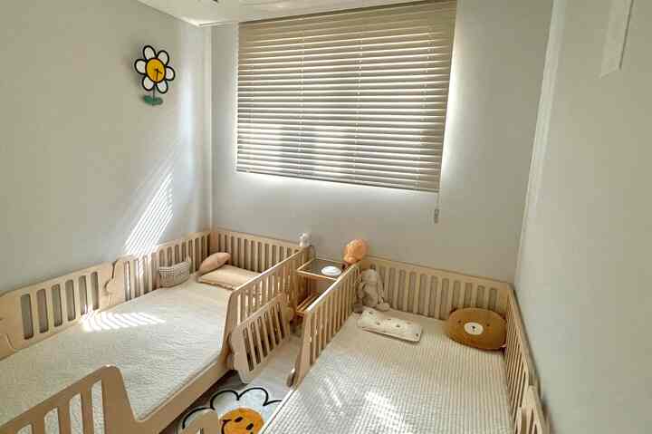 ナチュラルカラーの子供部屋、低床の木製ベッド2台とトッパーマットレスが安全で快適な雰囲気を演出するインテリア