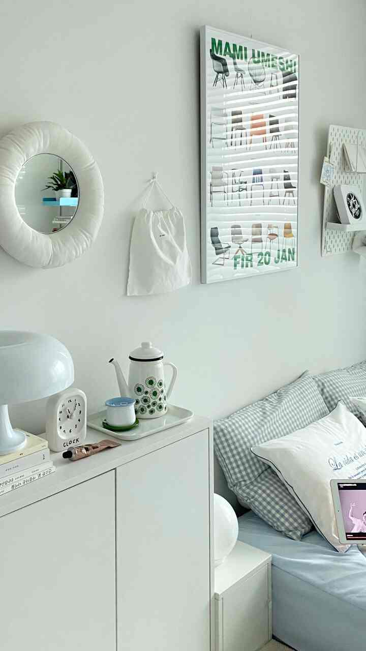 ホワイトとブルーの色調の寝室、すっきりとした収納家具とブルーチェックの枕が配置されたナチュラルでミニマルな印象的な空間