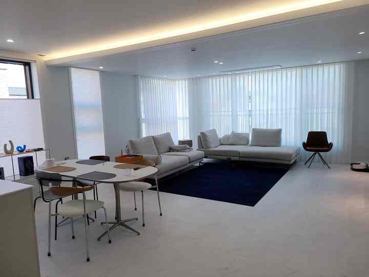 ホワイトとネイビーカラーのシンプルモダンなリビング、ソファとダイニングテーブルが配置された清潔感のある空間