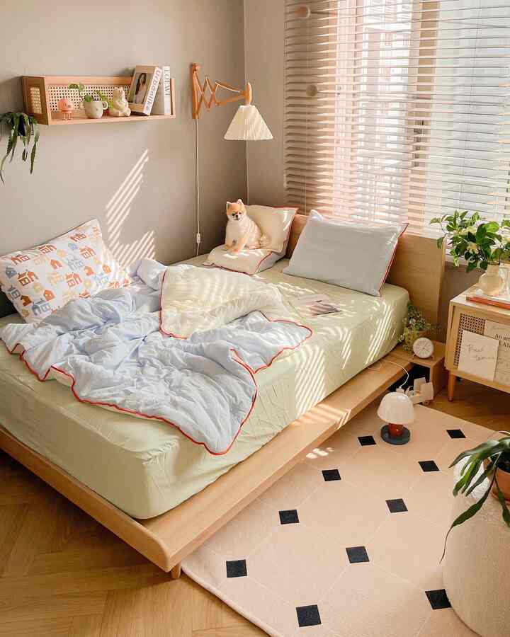 暖かい木目調とナチュラルな色調の寝室、ベッドの上に犬が座っている落ち着いた空間