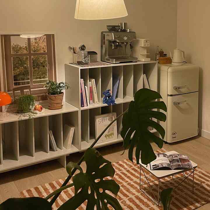 Warm natural toned kitchen space featuring mini fridge and coffee machine on shelves, creating a cozy home cafe atmosphere