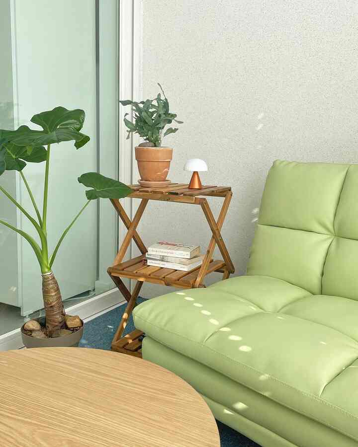 ナチュラルな木目調とライトグリーンのベランダ休憩スペース、ソファと棚が配置された雰囲気のあるインテリア