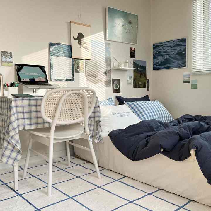Natural and simple bedroom featuring navy bedding, checkered desk, and cozy interior with soft natural light
