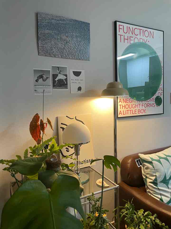 Natural-toned living room featuring green plants, brown leather sofa, and illuminated lamps