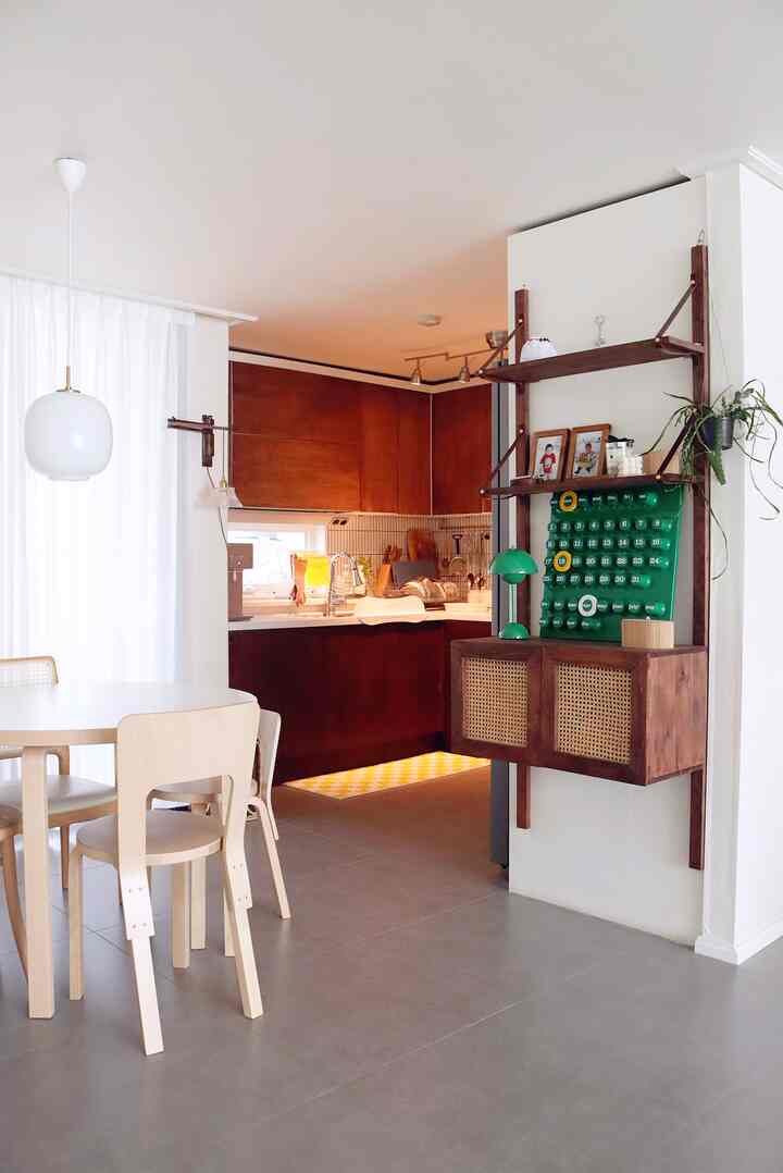 Natural vintage kitchen with white walls, brown wood tones, and wooden dining chairs around a table