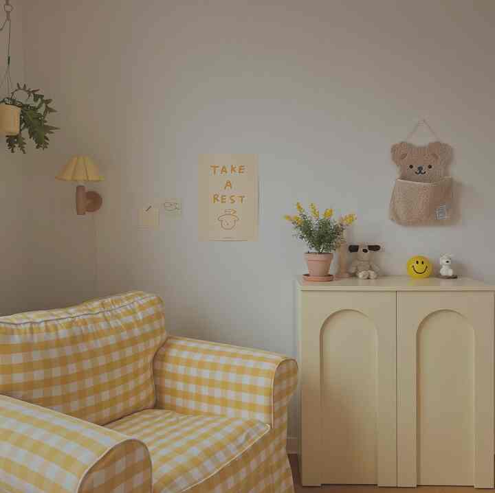 A yellow and natural color living room featuring a checked armchair and beige cabinet, creating a calm and tidy atmosphere