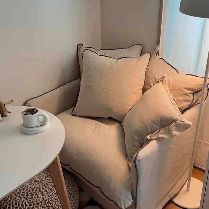 Beige-tone sofa with coffee table and floor lamp in a compact and minimal living room