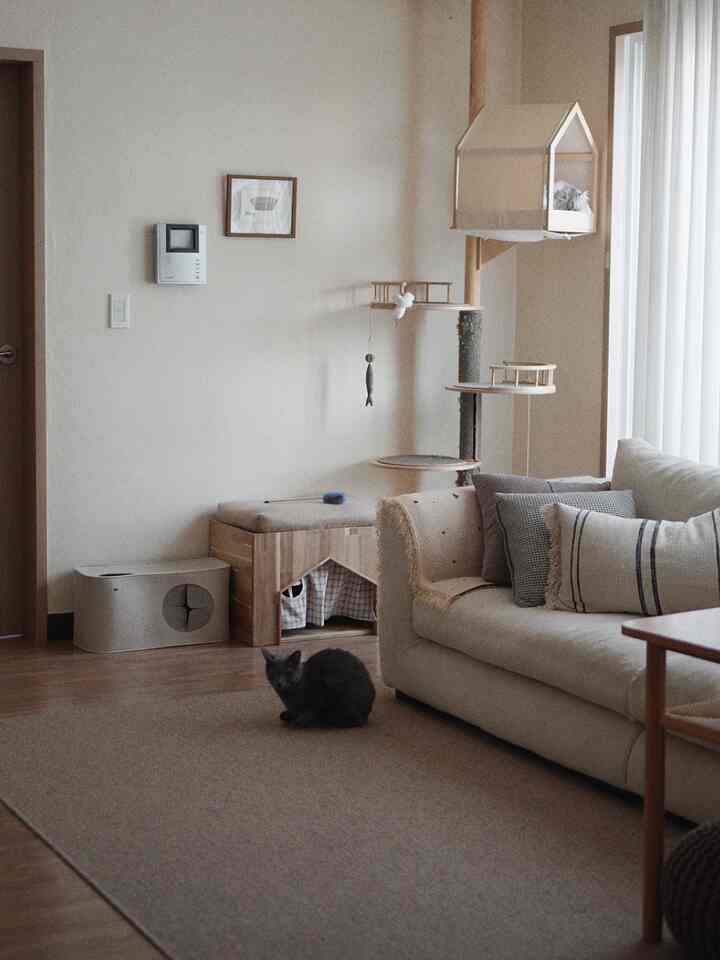 Natural beige and wood-tone living room featuring a cat tower with two cats, creating a cozy atmosphere