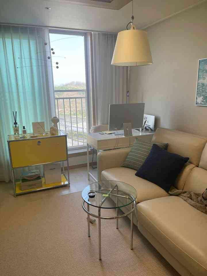 Beige and white toned 20-pyeong living room featuring a beige sofa and white desk with natural atmosphere