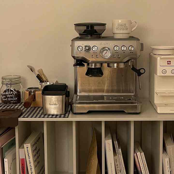 Natural toned home cafe featuring Breville espresso machine, bookshelf and coffee accessories with cozy atmosphere